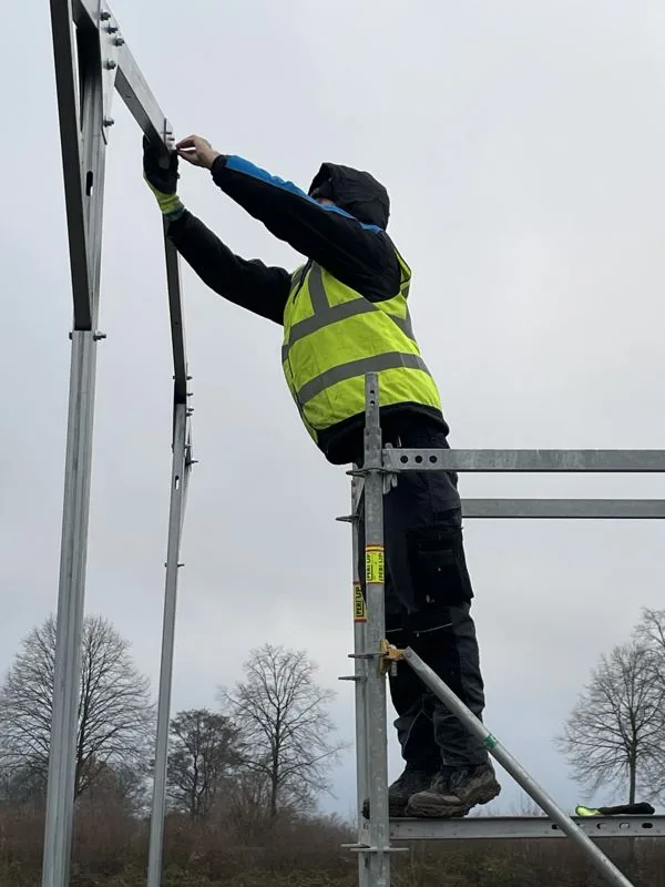 Pracovník KarmaPower při instalaci ocelové konstrukce